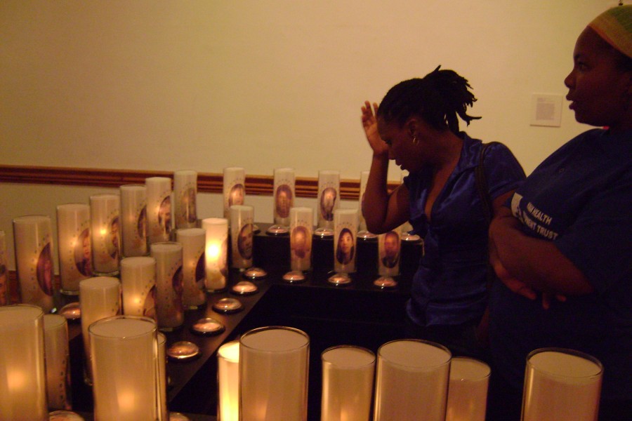 Visitors reacting to the candle component of Jean Carlomusto’s *Offerings*