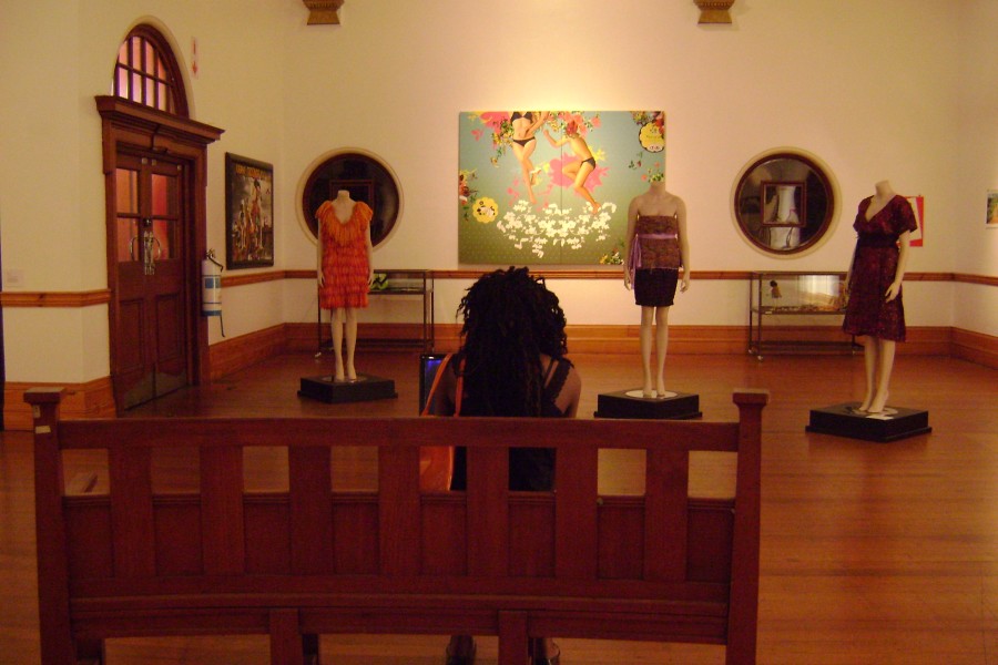 Visitor seated before works displayed in the gallery