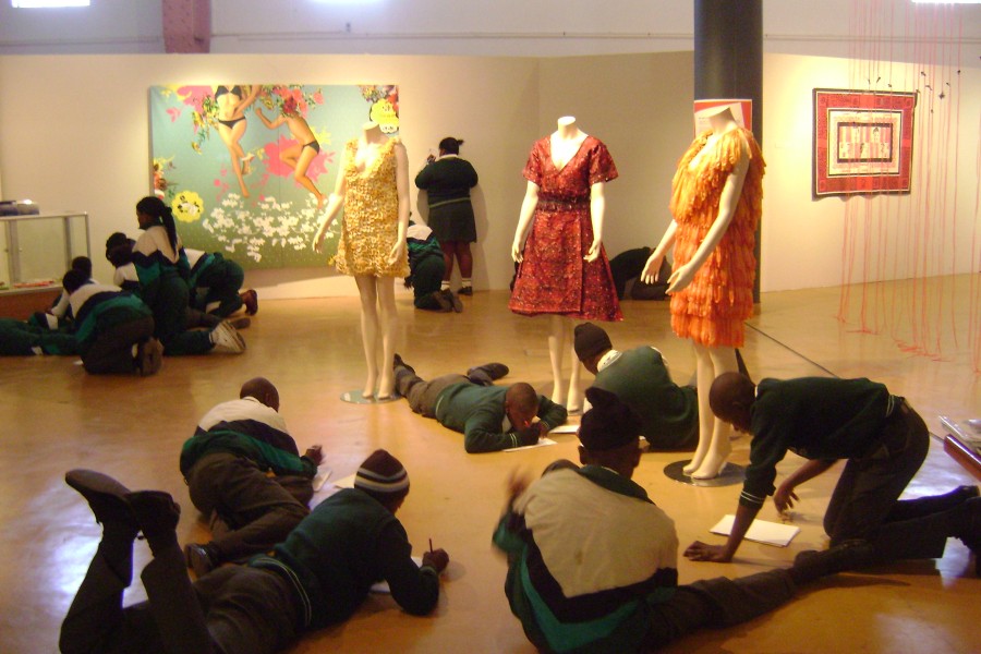 Visitors sitting and writing in the gallery