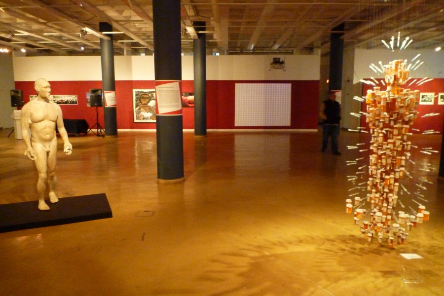 Wide gallery view with numerous artworks and wall-text panels