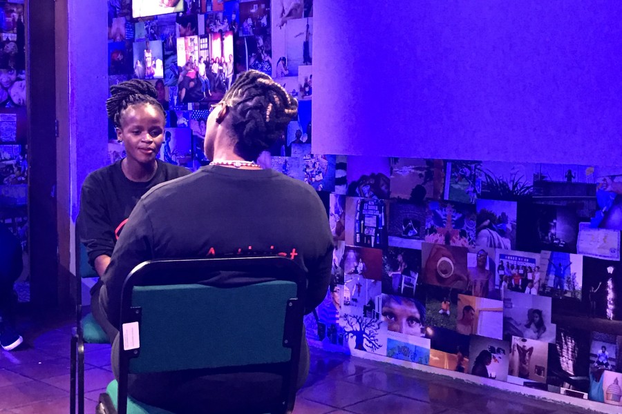 Through Positive Eyes artivist Elihle seated and speaking while facing another artivist