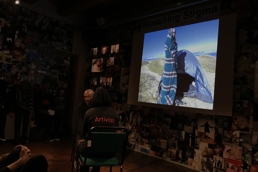 A Through Positive Eyes artivist sharing a personal story accompanied by a projected photograph