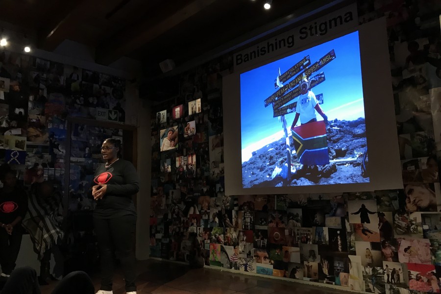 A Through Positive Eyes artivist performing in front of a projected photograph