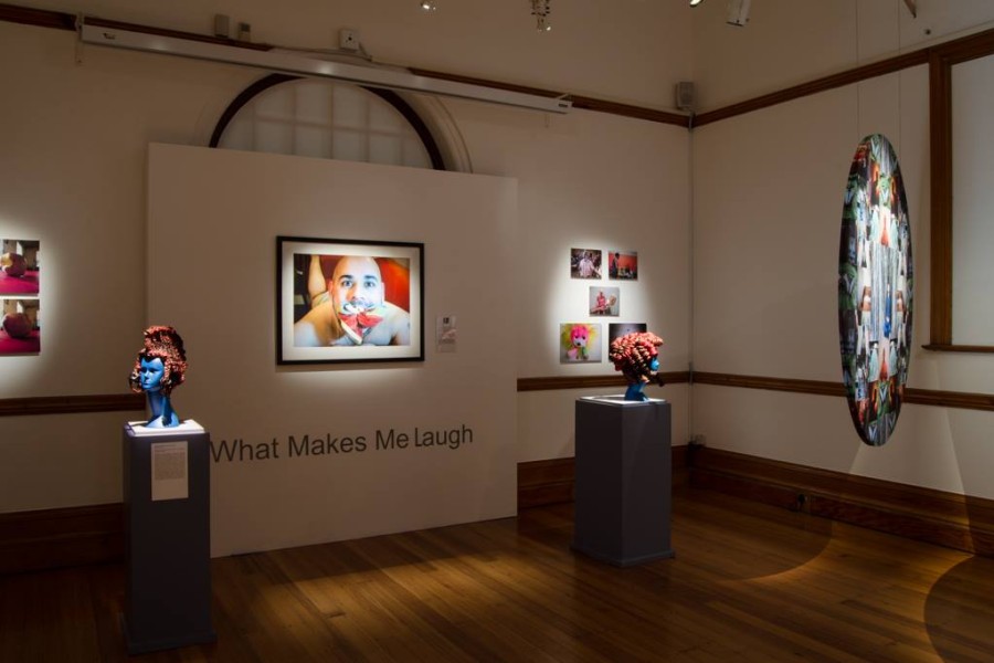 Multiple works by Through Positive Eyes artivists displayed in the gallery
