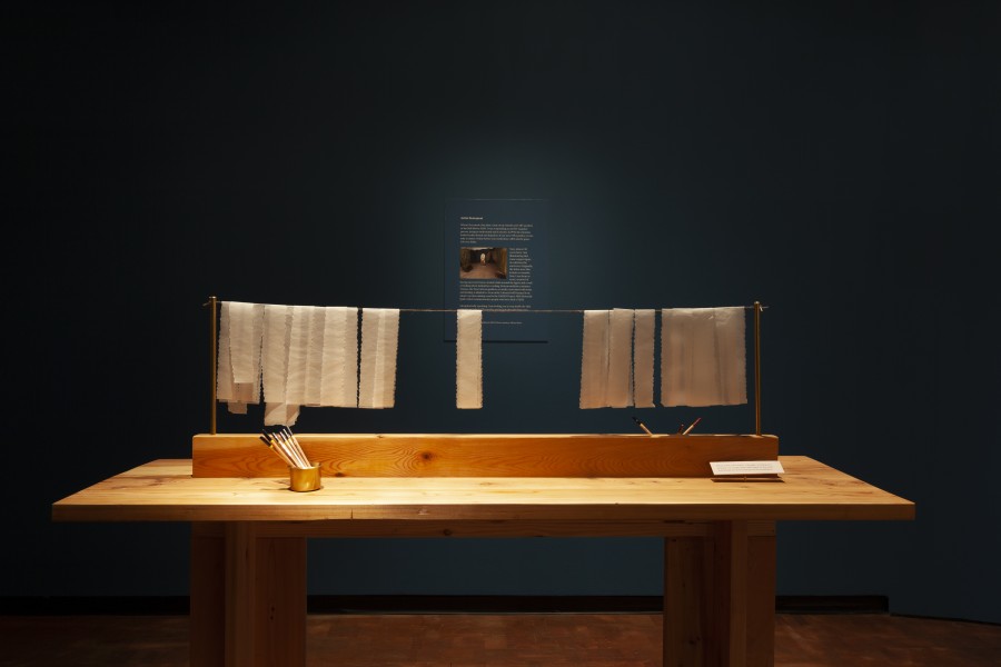 Writing station with long paper slips for visitor reflections