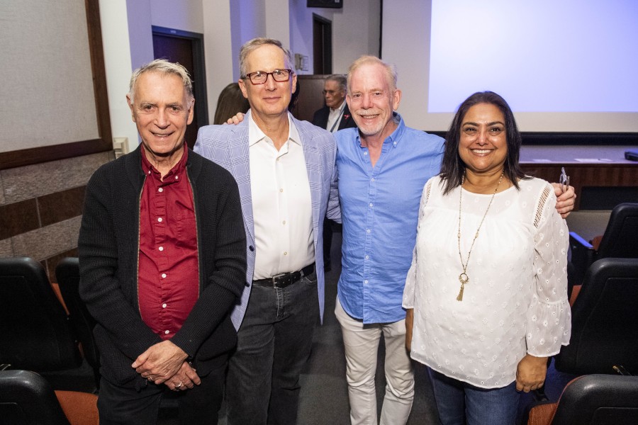 David Gere posing with visitors at the exhibition opening