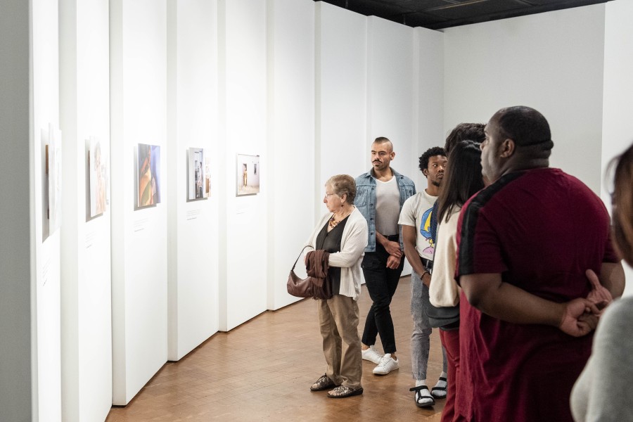 Visitors viewing photographs and stories by Through Positive Eyes artivists