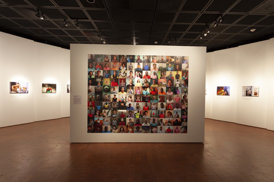 Exhibition entrance with Gideon Mendel’s 122 Faces of Through Positive Eyes displayed at center