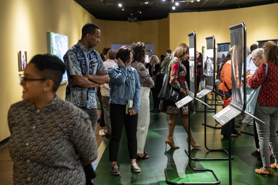 Visitors viewing artivist photographs, stories, and portraits by Gideon Mendel