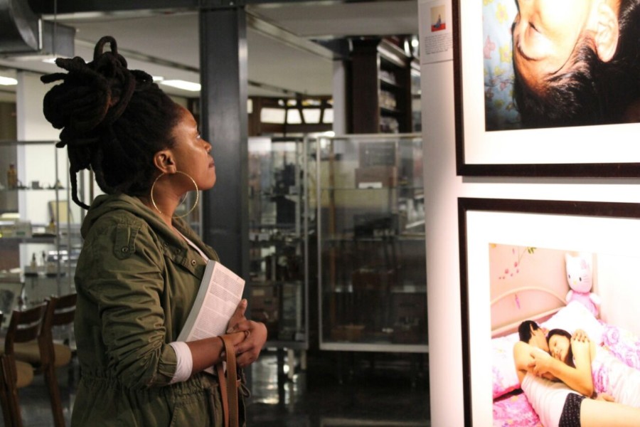 A visitor viewing a photograph by a Through Positive Eyes artivist