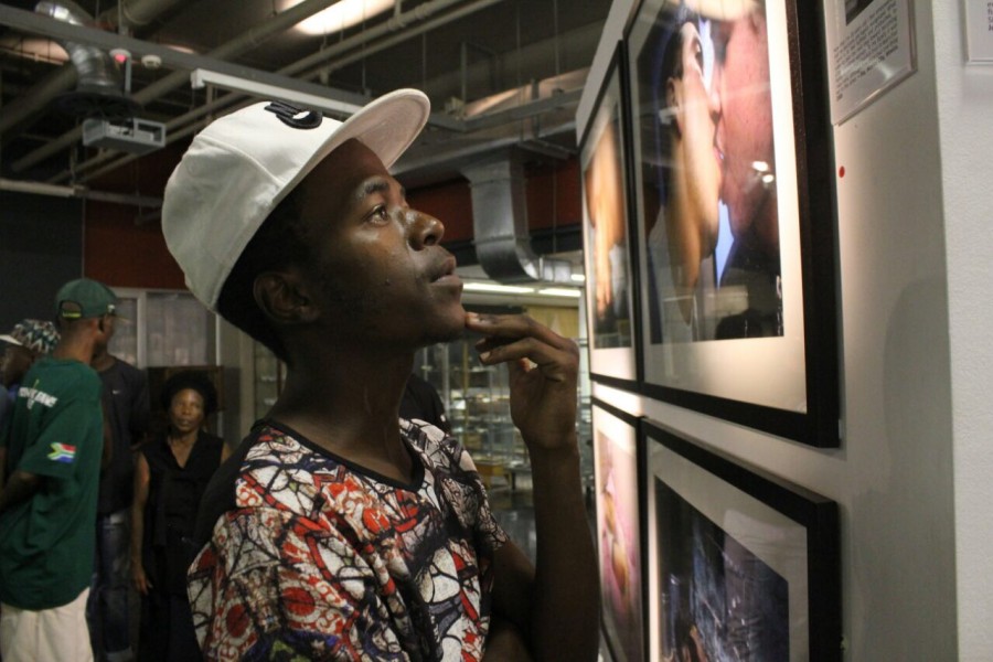 A visitor viewing a photograph by a Through Positive Eyes artivist