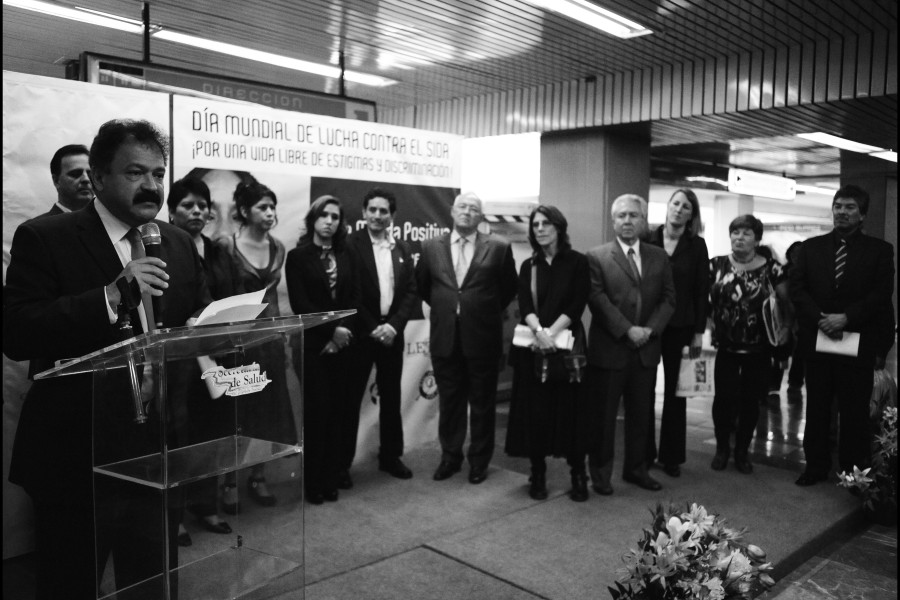 A crowd onstage with a speaker at the exhibition opening