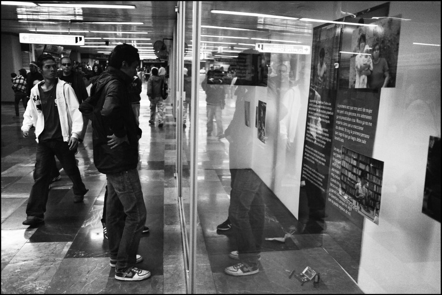 Two people viewing photographs and stories by Through Positive Eyes artivists